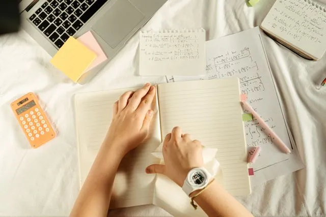 GRE test preparation notes with laptop calculator and study materials