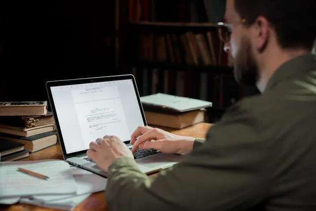 GMAT applicant studying with laptop and notes for business school preparation