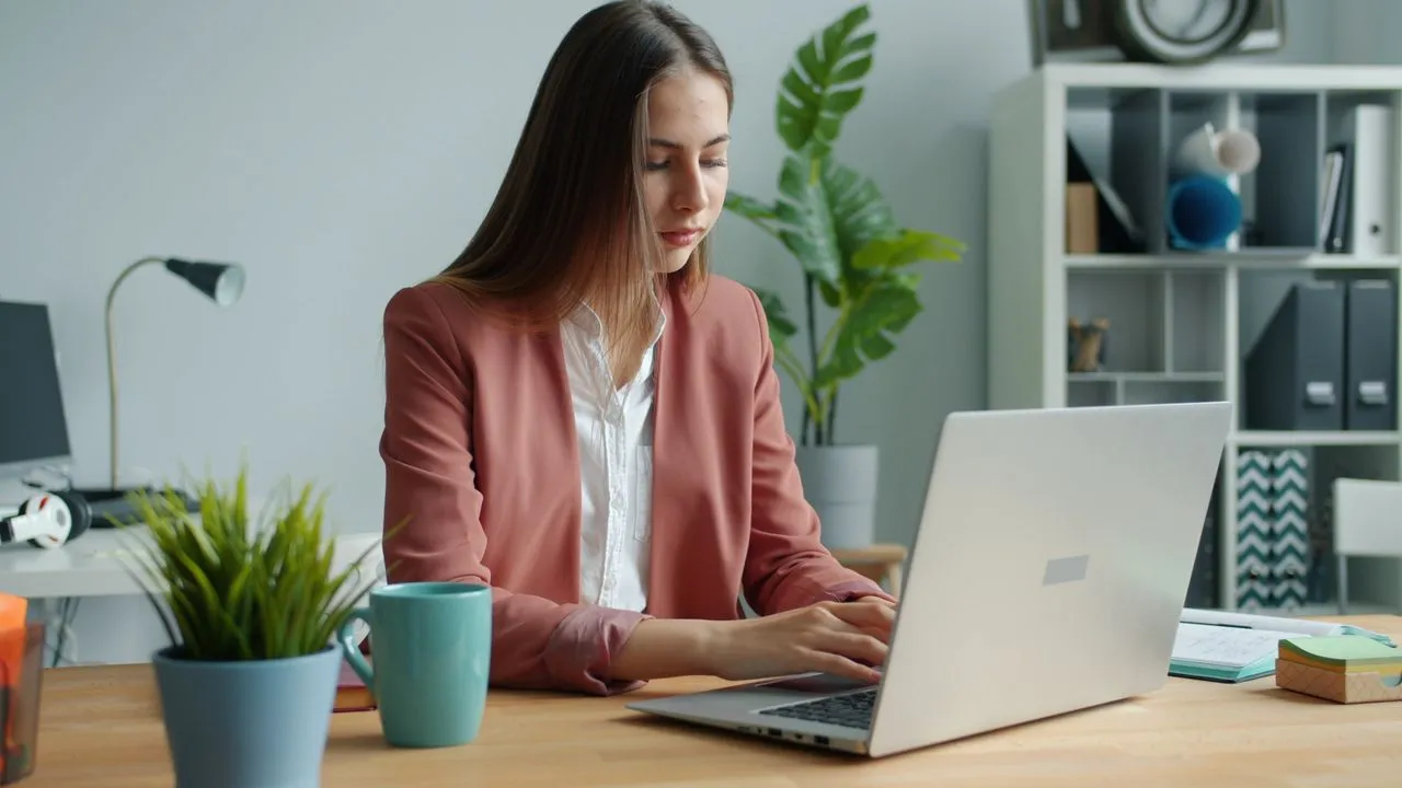 Young professional preparing for GMAT with laptop at a modern workspace